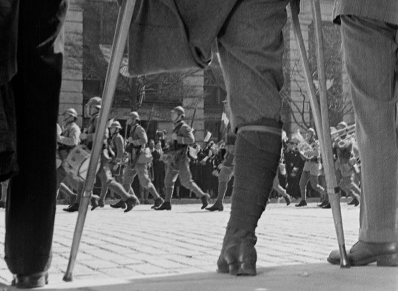 A parade is observed by a veteran amputee in the opening montage