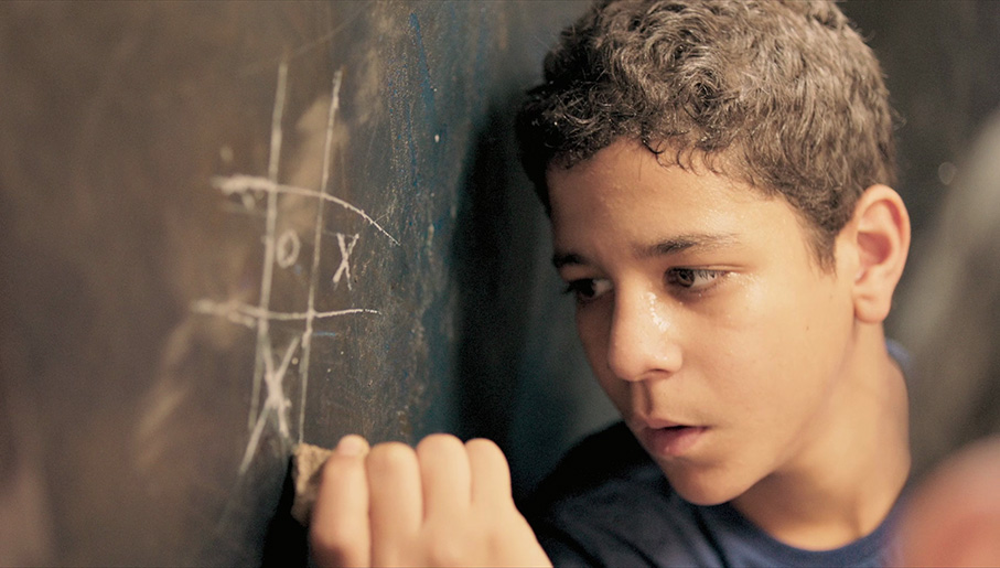 Nagwa's son adds a cross to an anonymous game of oughts and crosses