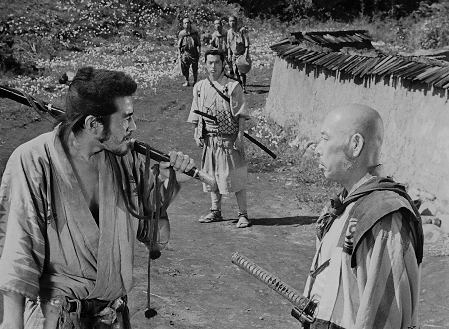 Kikuchiyo confronts Kambei as Katsushirō watches on